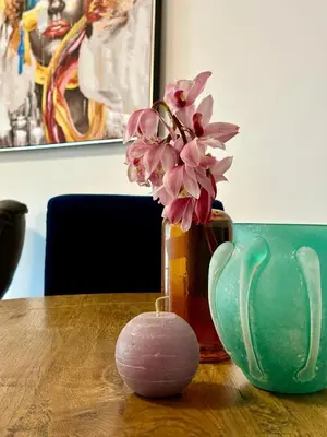 a vase with pink flowers in it sitting on a table at Le Victor Hugo de la Robine in Narbonne
