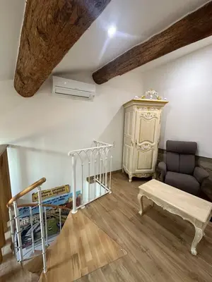 a living room with a couch and a table at Studio familial a Mezzanine presbytère dans l'Église in Narbonne