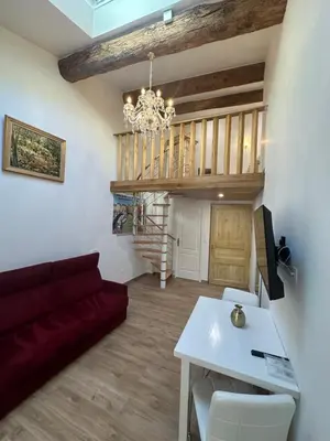 a living room with a red couch and a table at Studio familial a Mezzanine presbytère dans l'Église in Narbonne