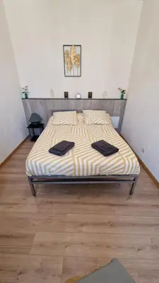 a bedroom with a bed with black towels on it at Appartement T2 avec balcon proche centre-ville NARBONNE in Narbonne