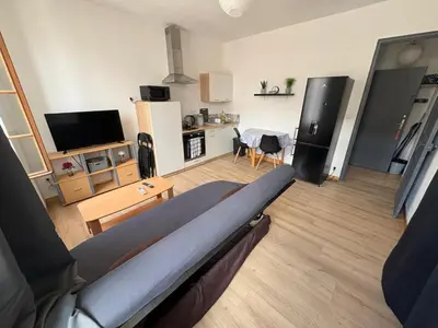 a living room with a bed and a kitchen at Appartement T2 avec balcon proche centre-ville NARBONNE in Narbonne
