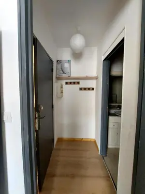 a hallway with a door leading to a kitchen at Appartement T2 avec balcon proche centre-ville NARBONNE in Narbonne