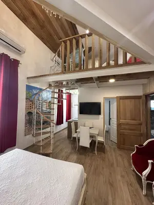 a bedroom with a loft bed and a dining room at Suite a Mezzanine dans l'Église du Couvent in Narbonne