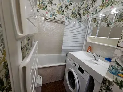a bathroom with a sink and a washing machine at Logis des Palmiers YourHostHelper in Gruissan
