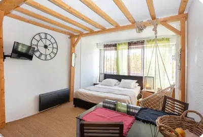 a bedroom with a bed and a clock on the wall at Studio L'air marin in Gruissan