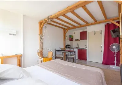 a bedroom with a white bed and a kitchen at Studio L'air marin in Gruissan
