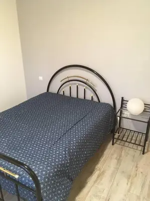 a bed in a room with a blue comforter at Gîte aux Aspres Logement de 65m² (4pers) in Fontcouverte