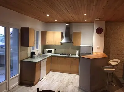 a kitchen with wooden cabinets and a stove top oven at Gîte aux Aspres Logement de 65m² (4pers) in Fontcouverte