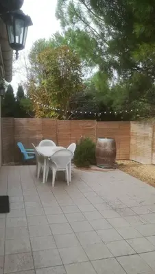 a patio with two white chairs and a table at Gîte aux Aspres Logement de 65m² (4pers) in Fontcouverte