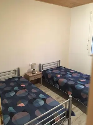 a bedroom with two beds and a table with a lamp at Gîte aux Aspres Logement de 65m² (4pers) in Fontcouverte