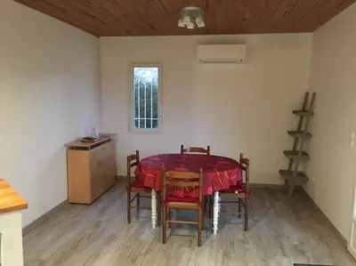 a dining room with a table and chairs and a window at Gîte aux Aspres Logement de 65m² (4pers) in Fontcouverte