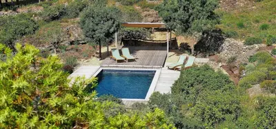 a swimming pool with two lounge chairs and a deck at Le Chant des Pierres in Saint-Pierre-des-Champs