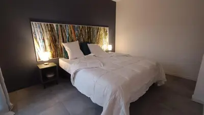 a bedroom with a large white bed with two lamps at Le Chant des Pierres in Saint-Pierre-des-Champs
