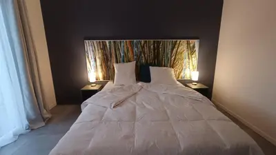 a bedroom with a white bed with two night stands at Le Chant des Pierres in Saint-Pierre-des-Champs