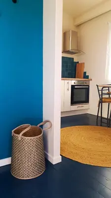 a kitchen with a blue wall and a table at Le Chant des Pierres in Saint-Pierre-des-Champs