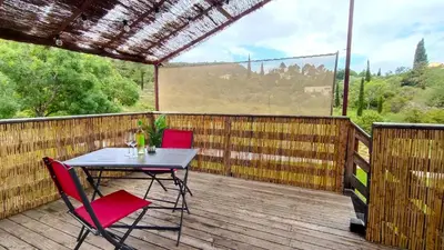 a table and chairs on a deck with a view at Le Chant des Pierres in Saint-Pierre-des-Champs