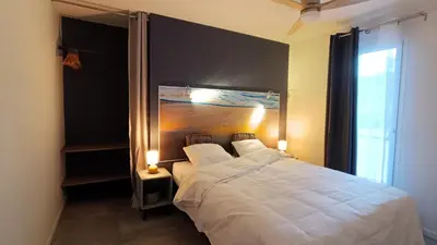 a bedroom with a large white bed and a window at Le Chant des Pierres in Saint-Pierre-des-Champs