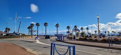 an empty street with palm trees on a beach at MOBILE HOME Clim-Piscine -Terrasse -Parking -6 personnes in Port-la-Nouvelle