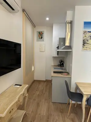 a living room with a table and a kitchen at Studio dans L'Eglise du Couvent in Narbonne