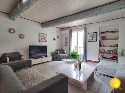 a living room with a couch and a tv at Coeur de Fitou Maison de village atypique avec terrasse in Fitou