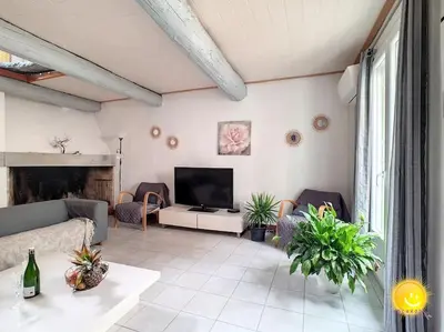 a living room with a couch and a television at Coeur de Fitou Maison de village atypique avec terrasse in Fitou