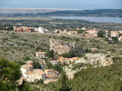 a small village on a hill with a body of water at Coeur de Fitou Maison de village atypique avec terrasse in Fitou