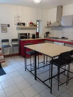 a kitchen with a table and chairs in it at Coeur de Fitou Maison de village atypique avec terrasse in Fitou