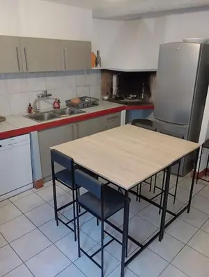 a kitchen with a table and two chairs and a sink at Coeur de Fitou Maison de village atypique avec terrasse in Fitou