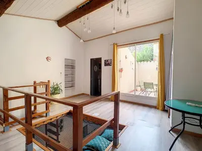 a living room with a staircase and a table at Le Temps Suspendu - Maison atypique avec terrasse in Fitou