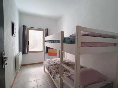 a bedroom with two bunk beds and a window at Le Temps Suspendu - Maison atypique avec terrasse in Fitou