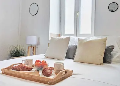a tray of bread and fruit on a bed at Le Barès in Carcassonne