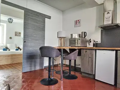 a kitchen with two bar stools and a counter at Le Barès in Carcassonne
