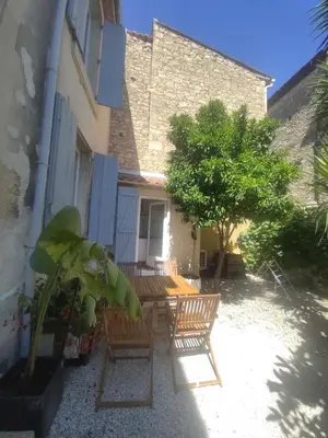 a patio with chairs and a tree in front of a building at Clim et extérieur entre mer, garrigue et réserve africaine in Portel-des-Corbières