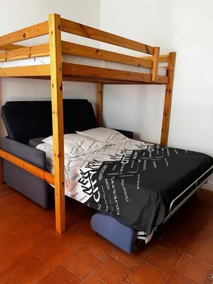 a bunk bed with a black and white comforter at Clim et extérieur entre mer, garrigue et réserve africaine in Portel-des-Corbières