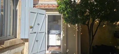 an open door of a building with a tree at Clim et extérieur entre mer, garrigue et réserve africaine in Portel-des-Corbières