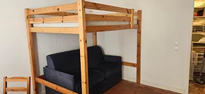 a bunk bed with a black chair in a room at Clim et extérieur entre mer, garrigue et réserve africaine in Portel-des-Corbières