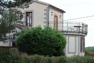 a white house with a balcony on top of it at Maison de charme avec vue sur la cité médiévale. in Carcassonne