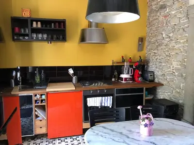 a kitchen with a counter and a table in a room at Maison de charme avec vue sur la cité médiévale. in Carcassonne
