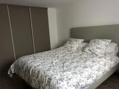 a bedroom with a bed with a comforter and pillows at Maison de charme avec vue sur la cité médiévale. in Carcassonne