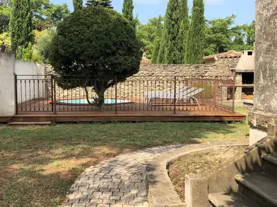 a fence with a tree in the middle of a yard at Maison de charme avec vue sur la cité médiévale. in Carcassonne