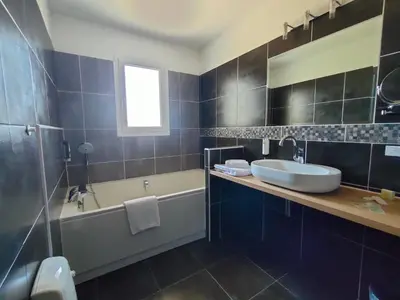 a bathroom with a tub and a sink and a bath tub at Hôtel Restaurant L'Art des Mets by Côté Jardin in Conilhac-Corbières