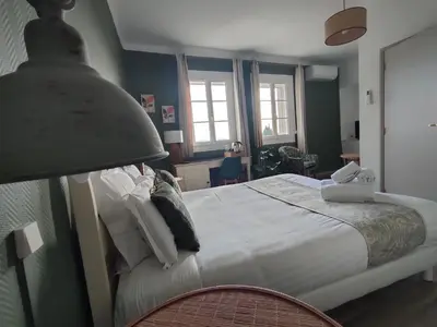 a bedroom with a large bed and a lamp at Hôtel Restaurant L'Art des Mets by Côté Jardin in Conilhac-Corbières