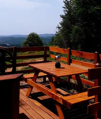 a wooden picnic table sitting on a wooden deck at Le Mobil'Dôme à Marie in Cambounès