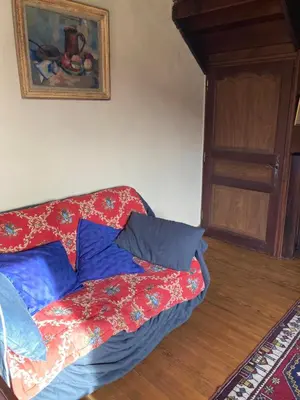 a bed with red and blue pillows in a room at Gîte col de la lauze avec vue sur le château de Montségur in Montferrier