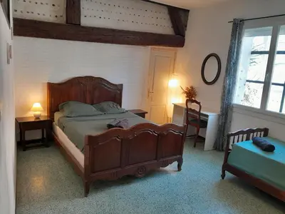 a bedroom with a bed and a desk and a window at hOMe-Shanti Galamus -- Relais Rando - vélo - moto in Saint-Paul-de-Fenouillet