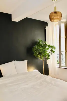 a bedroom with a white bed and a potted plant at Maison Merci - Maison d'hôtes in Carcassonne