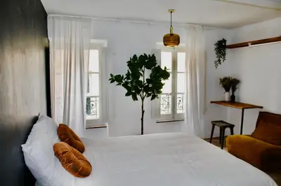 a bedroom with a large white bed with two pillows at Maison Merci - Maison d'hôtes in Carcassonne