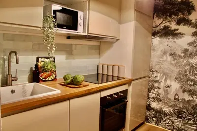 a kitchen with a sink and a microwave at Maison Merci - Maison d'hôtes in Carcassonne