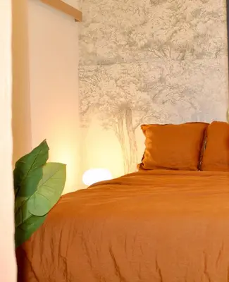 a bedroom with a bed with a painting on the wall at Maison Merci - Maison d'hôtes in Carcassonne