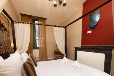 a bedroom with a bed and a fireplace at Balda'Quand Médiéval in Carcassonne
